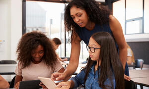 Teacher looking over student's shoulder