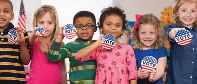 students holding vote buttons