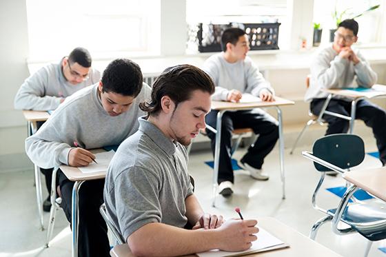 A diverse classroom of students work on an assignment