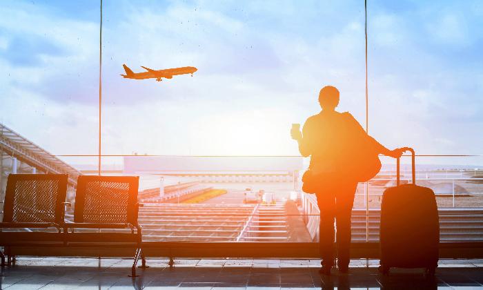 A traveler watches a plane take off