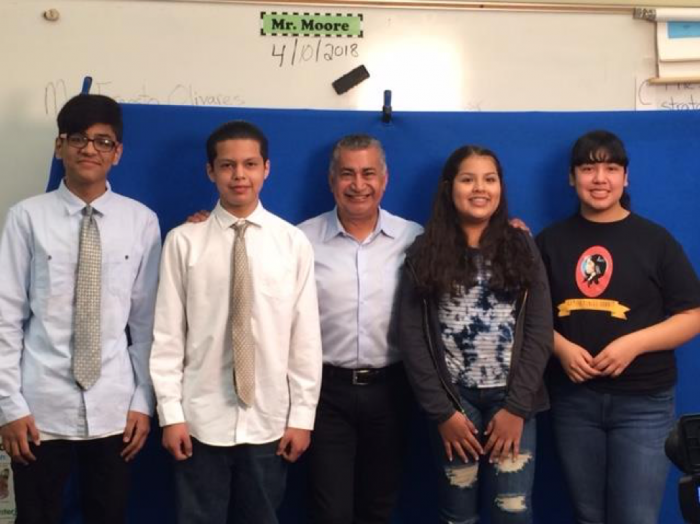 Four students and adult standing together for a group photo.