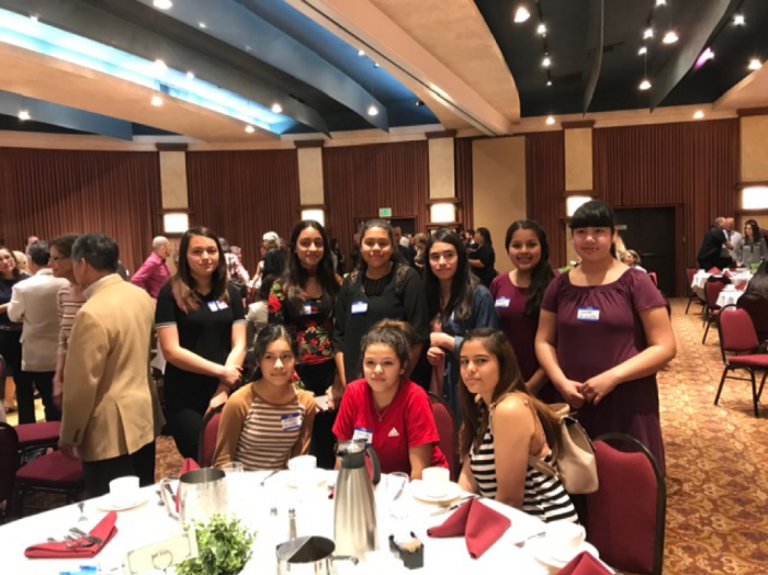 Group of students in formalwear gathered together at an event.