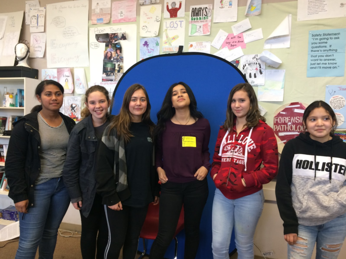 Several students in Santa Rosa classroom posing with interviewee for group shot.