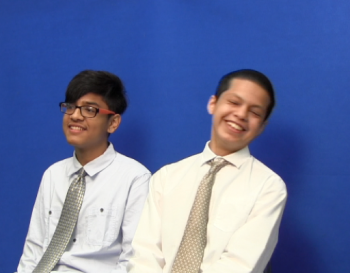 Two students sitting together, smiling and laughing.